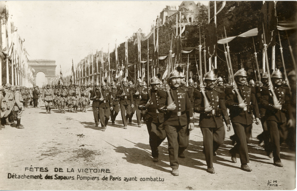 Un détachement de sapeurs-pompiers de Paris ayant combattu pendant la première guerre défile ce 11 novembre 1918, jour de l'armistice, sur les Champs-Elysées